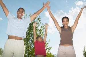 Portrait of a young couple and a child with their arms outstretched